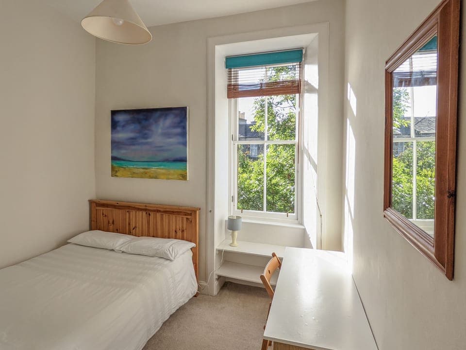 Second double bedroom with desk and chair.