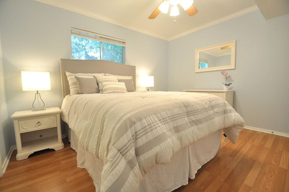 Cozy Bedroom features a Queen Bed w Designer headboard and natural Light.