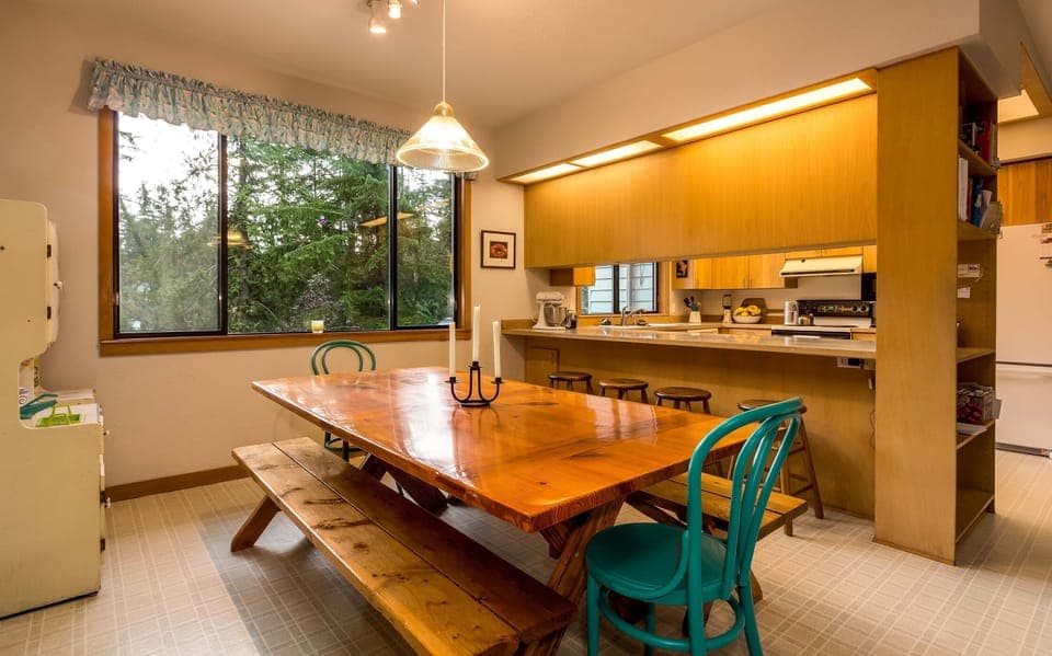 Dining area with large, hand-made table.  comfortably seats 8-10. View of bay.