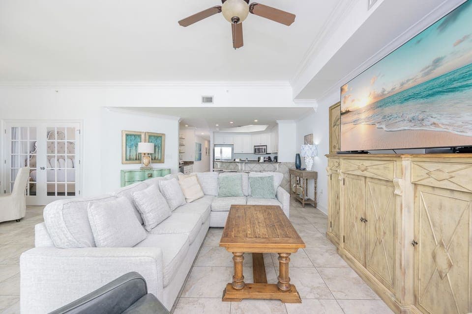 Living room featuring a plush sectional sofa with queen sleeper, rustic coffee table, and a large TV