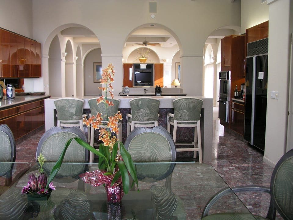 View of dining table and kitchen, with living room at far end.