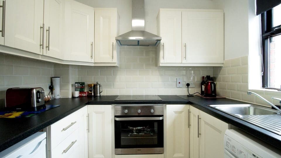 Kitchen with HoWashing Machine b cooker, oven, fridge & coffee maker