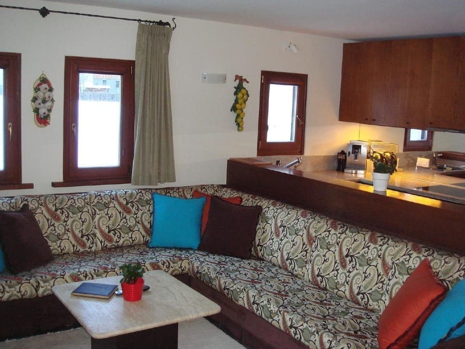View into the kitchen with sofa in front. The kitchen is equipped with a granite top.