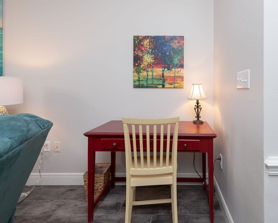 Settle into the cozy workspace with a vibrant red desk, complementary WiFi, and warm lighting for inspiration