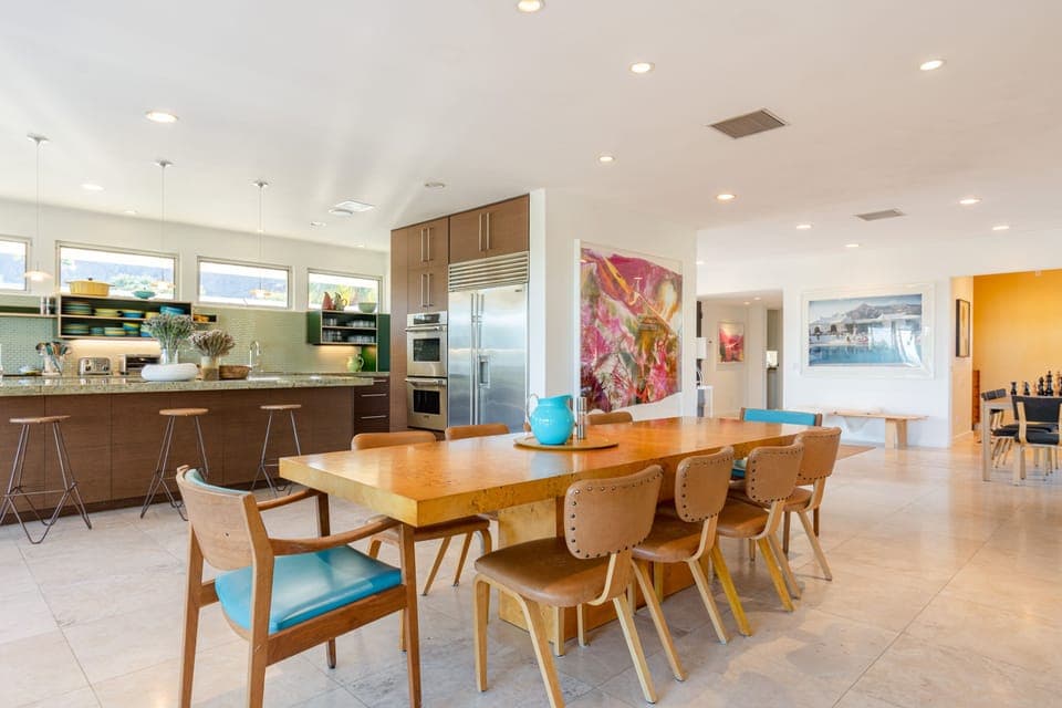 View of dining room and kitchen. Sit at the beautiful Milo Baughman table adorned by Thonet chairs. 