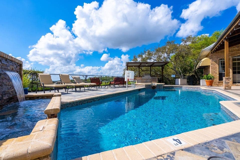 The pool also contains a waterfall and basketball hoop.
