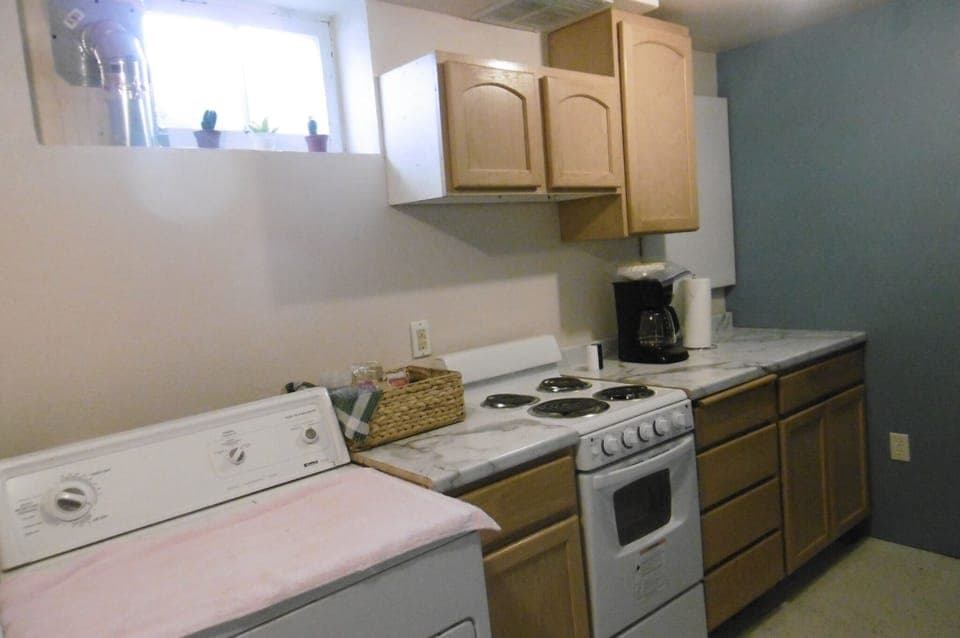 dryer, cupboards, new amana stove, coffee maker, paper towels and pots pans, 
