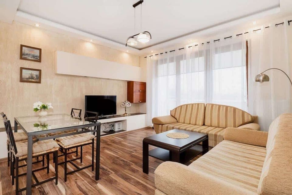 A comfortable living room with a beige sofa, matching armchairs, and a coffee table, creating an inviting space for relaxation.