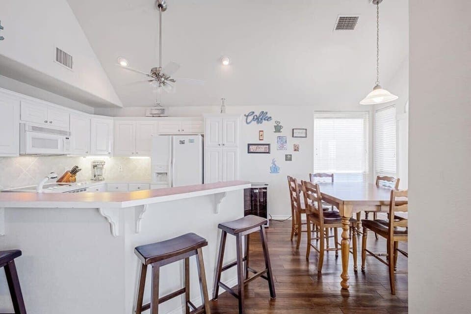 Dining area 6 seats at table with additional seats at the bar area.