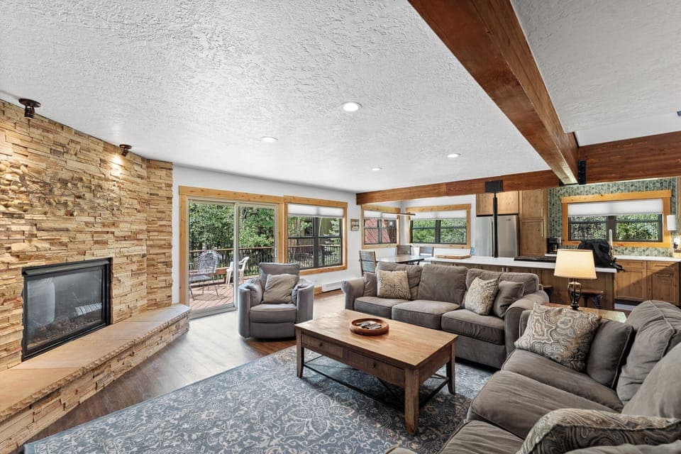 Cozy living area with large mounted flat screen TV, gas fireplace with beautiful stone surround, plenty of seating for your whole group and access to the main balcony.