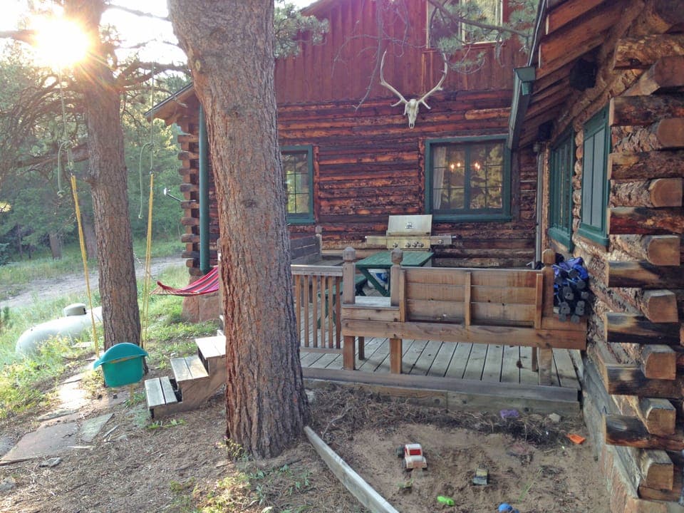Back porch with large grill, picnic table, chairs, benches, hammock, sand box.