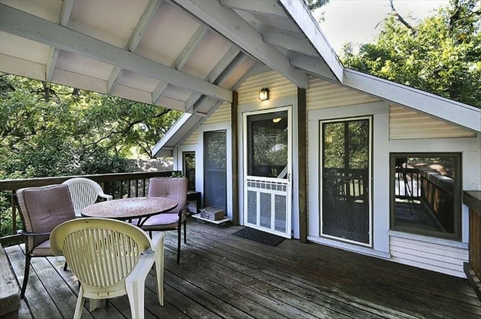 Private entrance to the large deck, with chairs and a table and many trees!