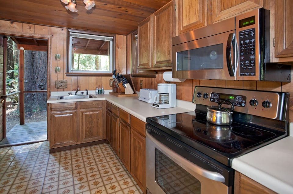 Kitchen with 4 burner electric stove, oven , microwave.
