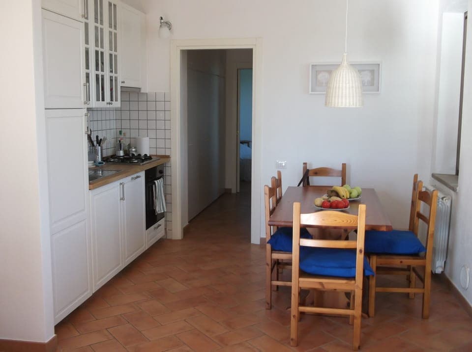 The kitchen, the dining table and the door leading to the bath and bed room.   