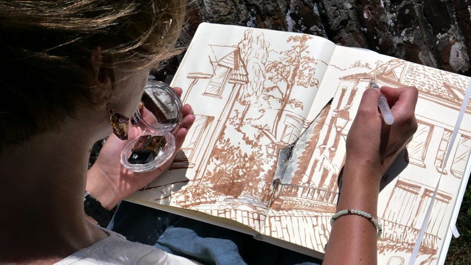 Kate K draws the view towards the valley from the church wall in front of the gîte and our house.