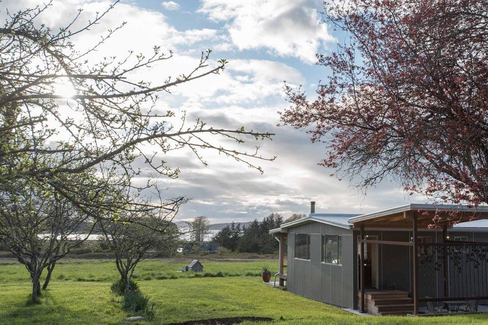 Front corner of the property with views of the backyard — and bay beyond that.