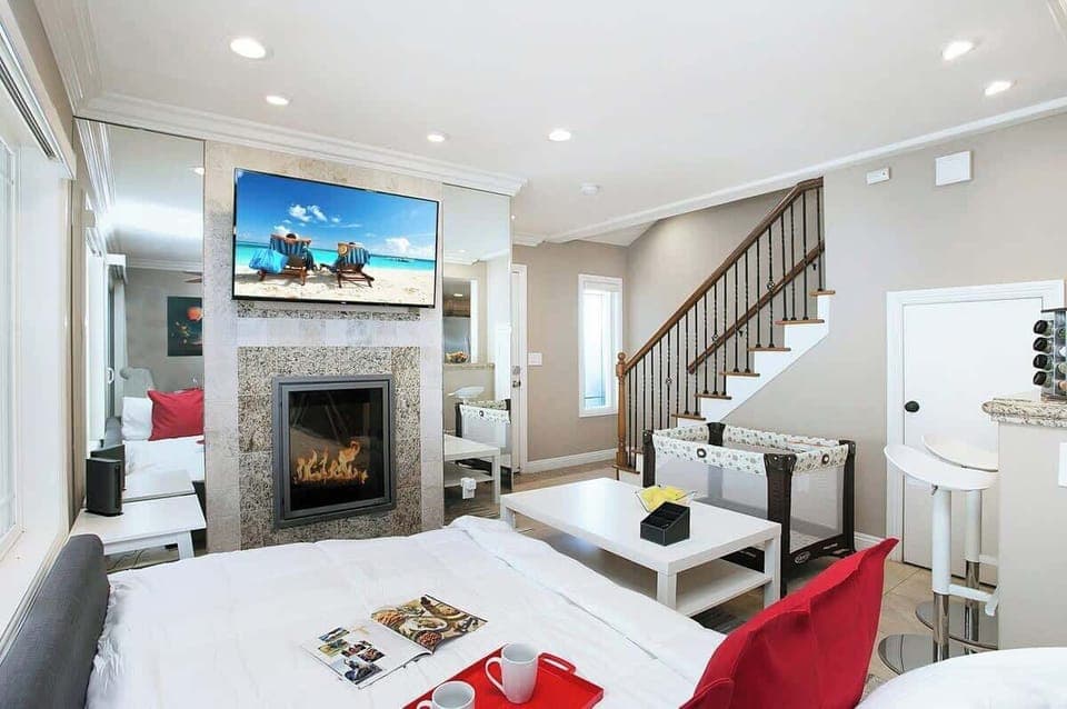 Sophisticated living room design with a sofa that opens up to full-size beds, 55” Smart TV,  office/kitchen seating, beautiful decor, and much more.