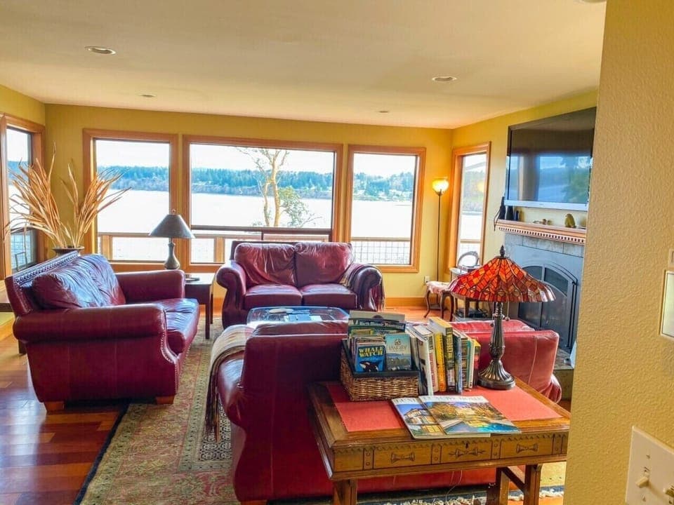 Living Room with lots of windows looking at the water and gas fireplace.
