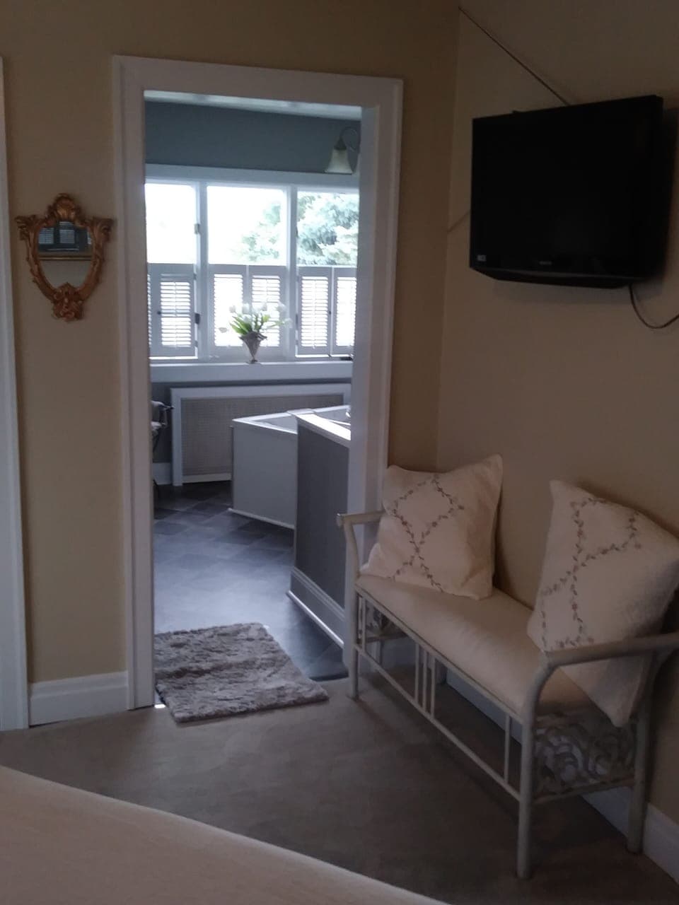 queen suite wall mount flat screen and entry to jacuzzi bathroom