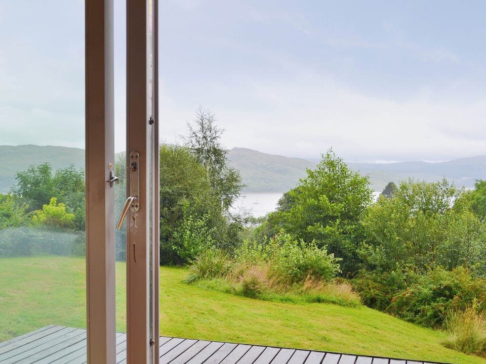 The french doors open up on to a small wooden terrace with views over the Morven Hills | West Bothy at Cluain Ghrianach, Laga, near Acharacle