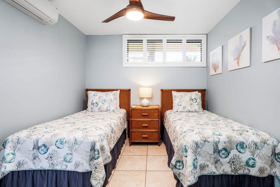 Twin bedroom offers flexible sleeping arrangements with crisp linens and cool A/C comfort.