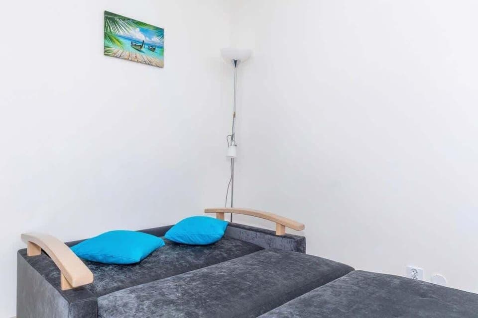 Welcoming living room with a double sofa bed, a cabinet, a television, and a dining table with chairs.