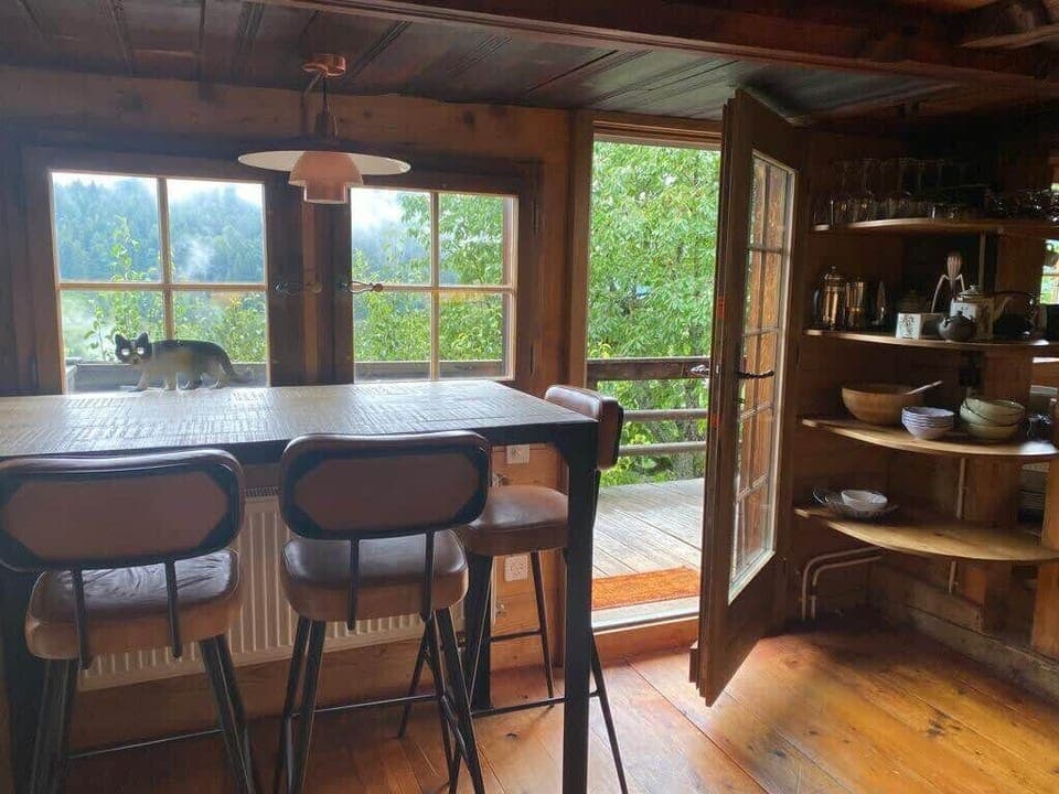 A high kitchen table located in front of stunning views and a balcony.