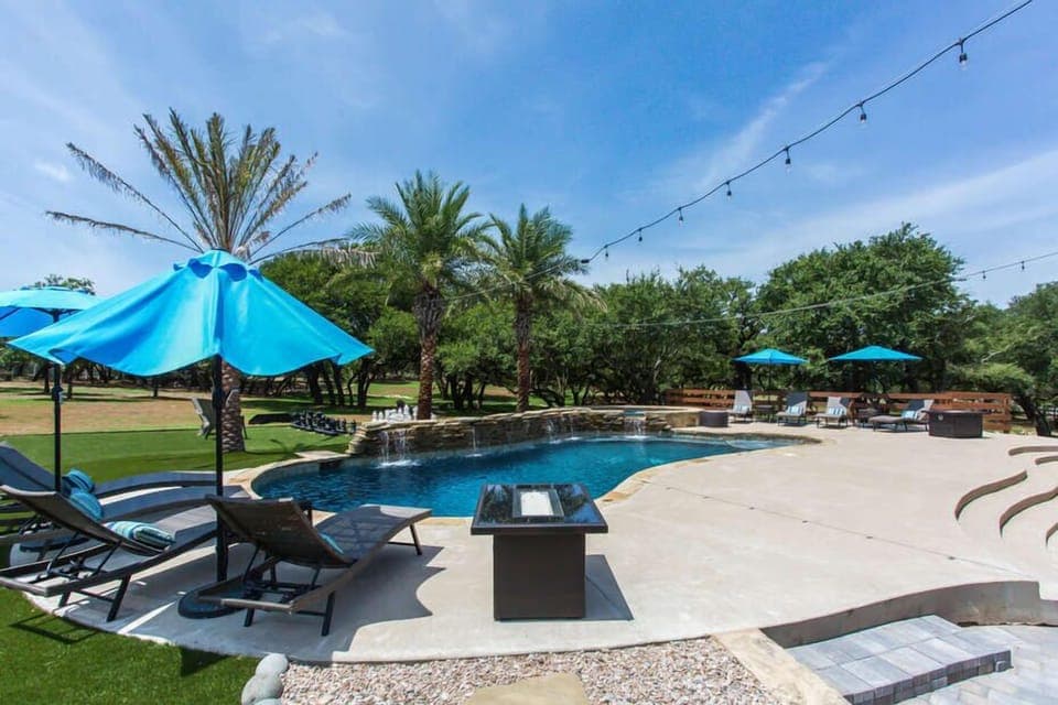 Serene Pool with a Stone Waterfall, Eight Lounge Chairs with Gas Fire Pits, and a 12-Seat Hot Tub