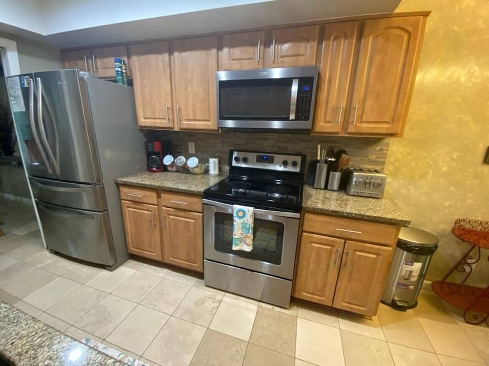 The kitchen has a built-in microwave, refrigerator, cabinets, and coffee pot.