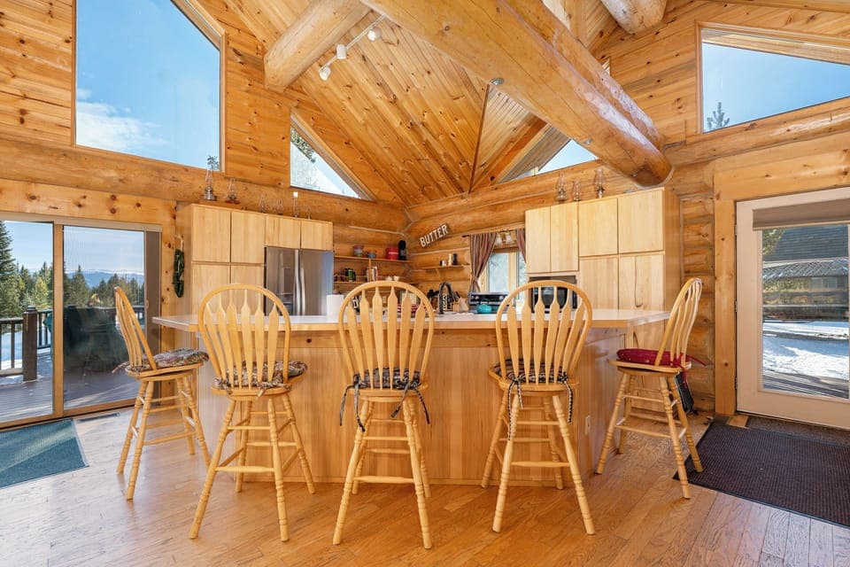 Gather around this stunning wooden kitchen island where rustic charm meets modern convenience in your mountain retreat.