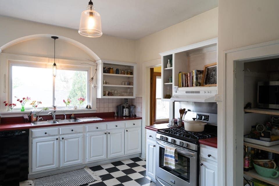 Kitchen with gas range, cookbooks, and le creuset dutch oven