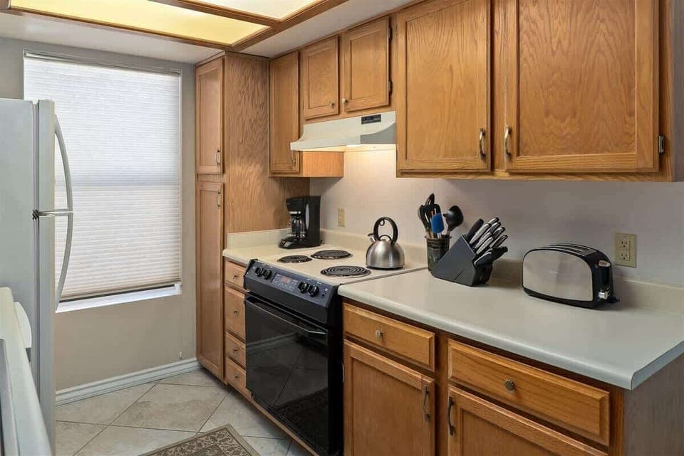 The kitchen is sunny and well-equipped with a Refrigerator, Stove, Coffee Maker, Cookware, Electric Oven and Range, Dishwasher and Microwave
