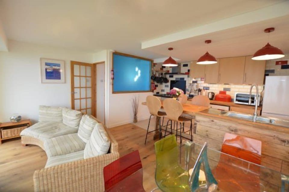 First floor: Open plan living area with a breakfast bar seating four guests. Separate dining area and sitting area looking out across the beach
