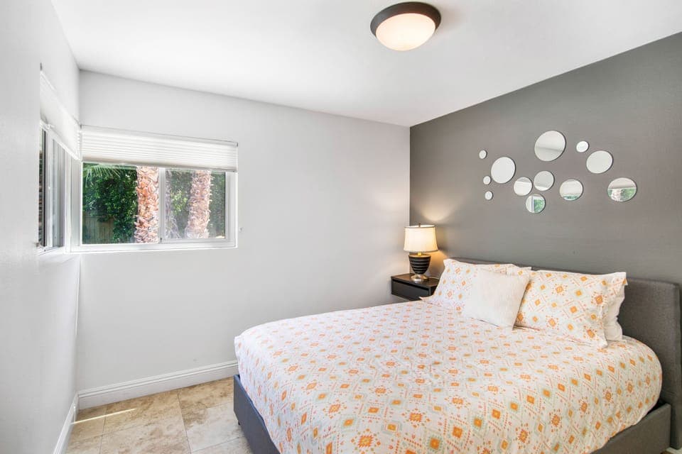 Bedroom 5 off the kitchen with a queen bed and views and access to backyard. 