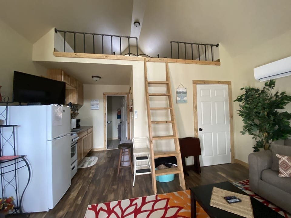 living room/kitchen - showing ladder to the large loft that has a queen bed