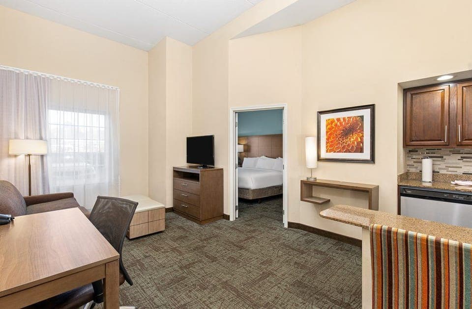 Open living area with a comfortable sofa, work desk, and kitchen.
