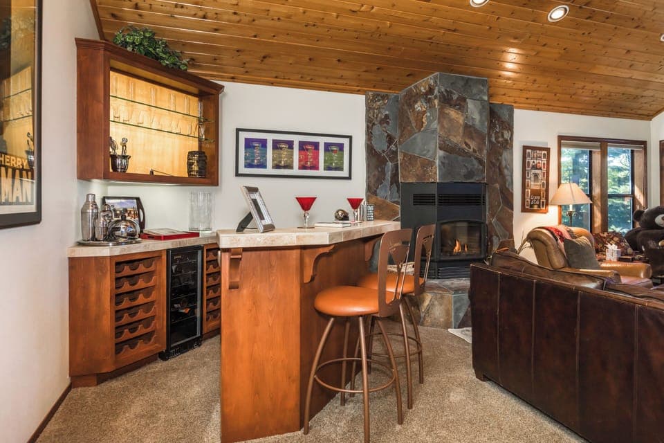 Full Bar with Wine Fridge Next To Natural Wood Fireplace In Living Room
