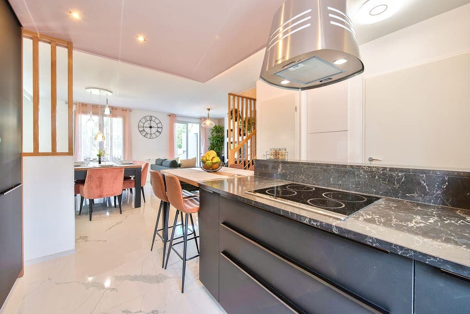 A fully equipped kitchen with a dining area and 4 high chairs, a refrigerator, 