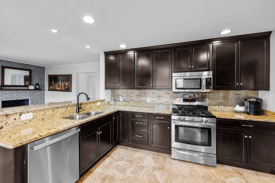 Fully equipped kitchen with stainless steel appliances and seating for 3 people and a bar with 4 stools 