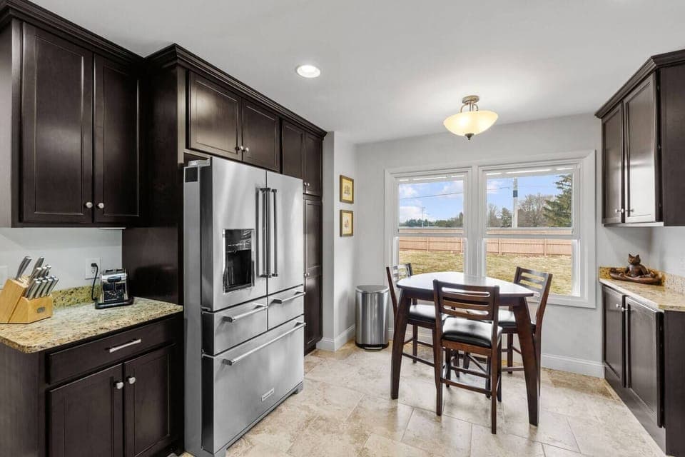 Fully equipped kitchen with stainless steel appliances and seating for 3 people and a bar with 4 stools 