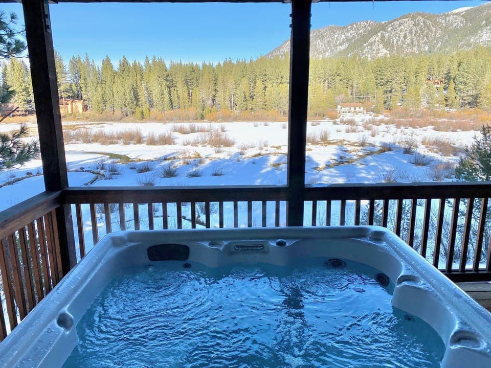 - Relax in the hot tub with mountain views  
- Scenic forest and snowy meadow backdrop  
- Lake Tahoe cabin rental with spa retreat