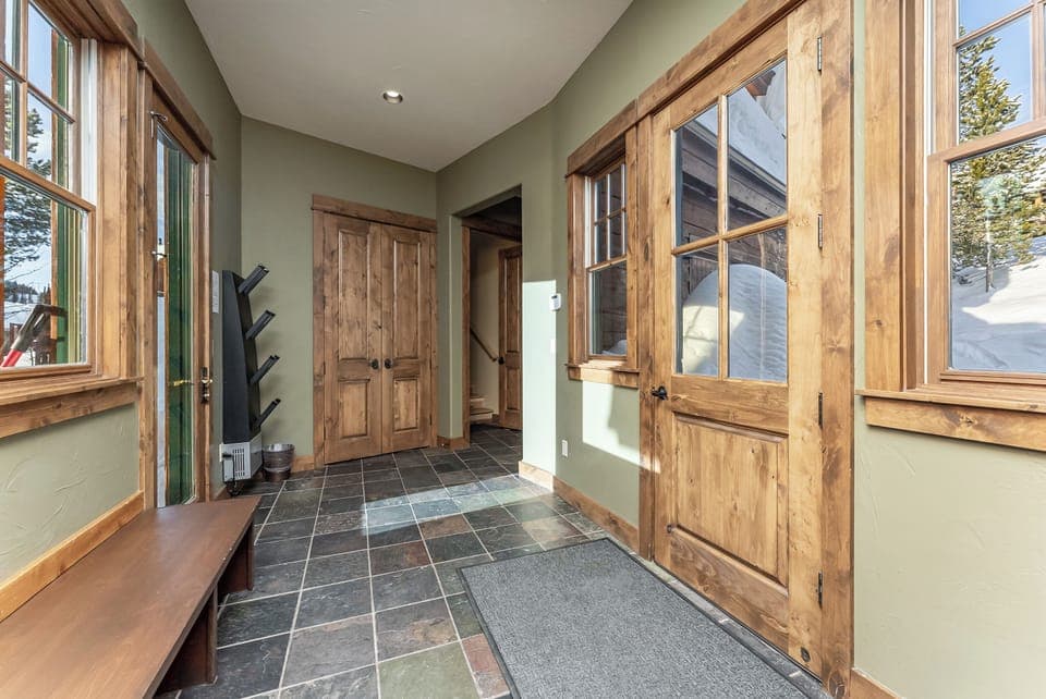Side entry way with hooks for ski gear, benches and boot dryers