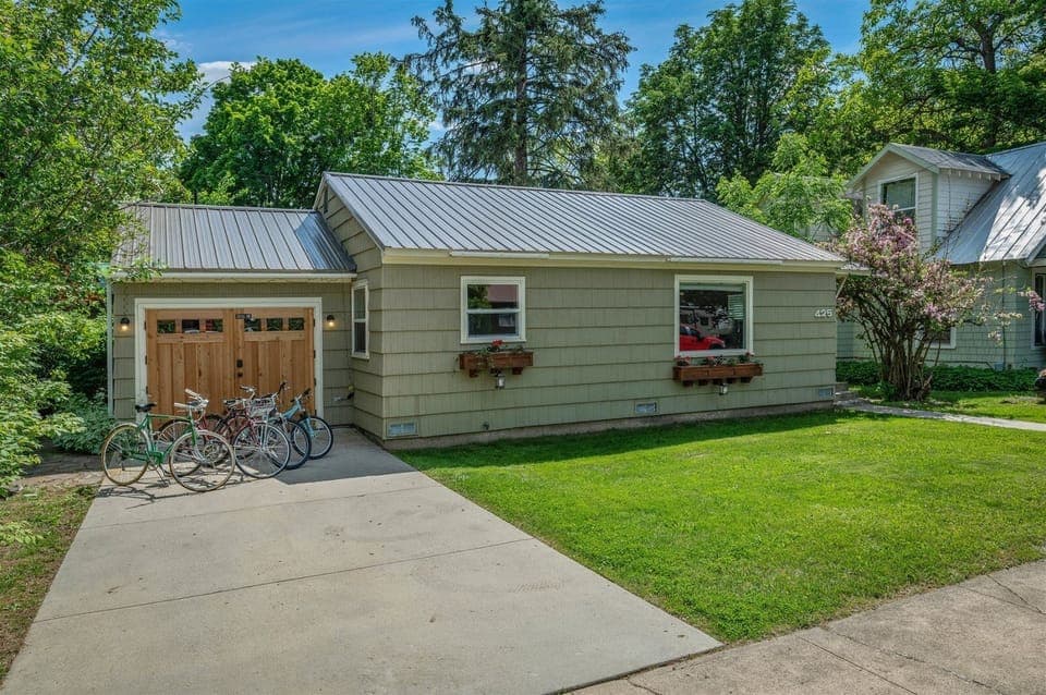 Cozy home with flower boxes, a tidy lawn, and bikes ready for exploring town.
