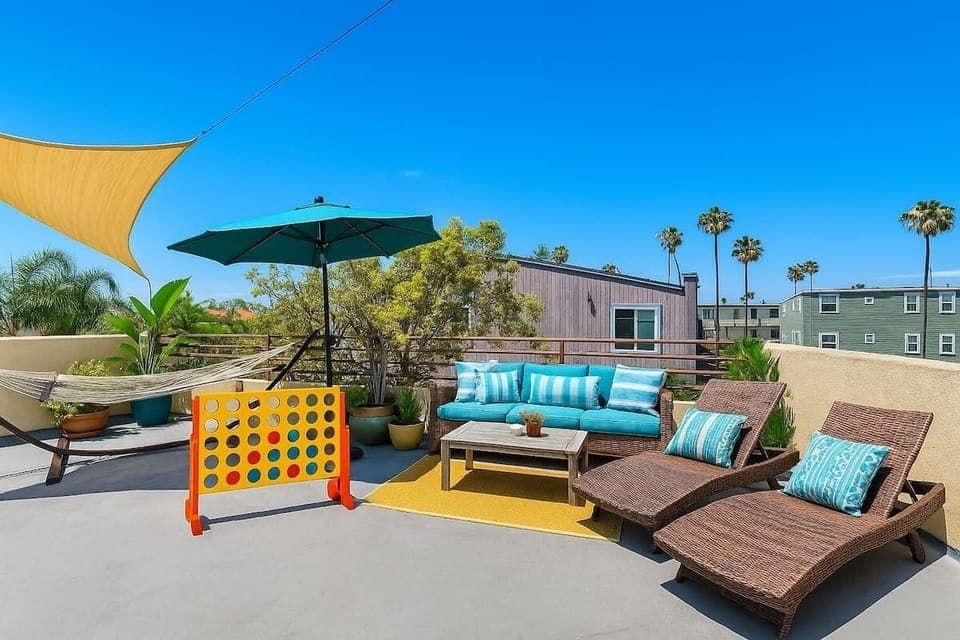 Bright and breezy rooftop retreat with comfy lounge chairs, a hammock, and tropical vibes under the California sun.