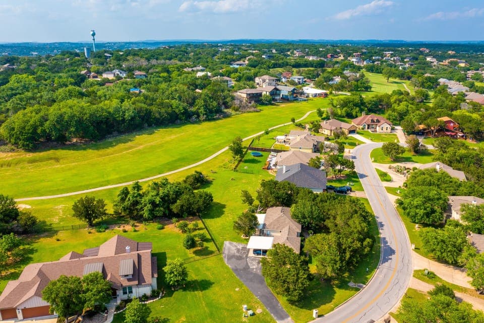 Aerial view of neighborhood shows lush greenery and mature trees