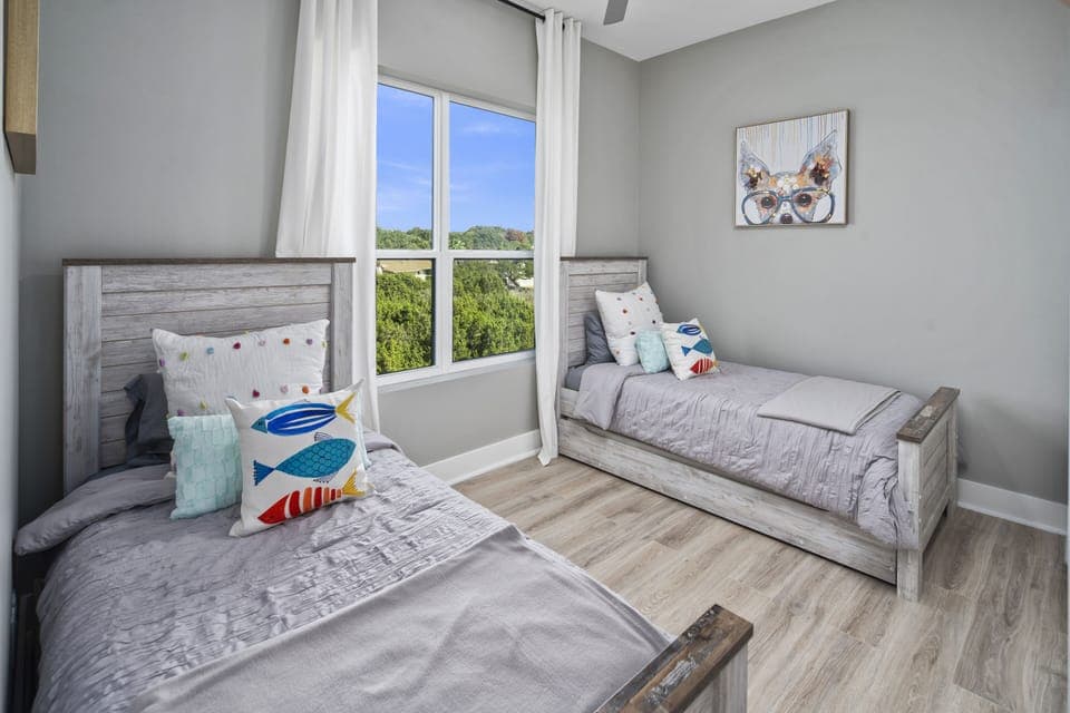 Guest room with 2 twin beds + two pull out twin trundles with sheets below.