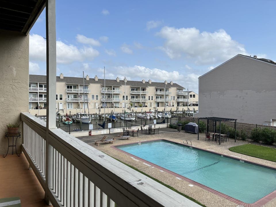 Large balcony view of pool, garden, marina and lake