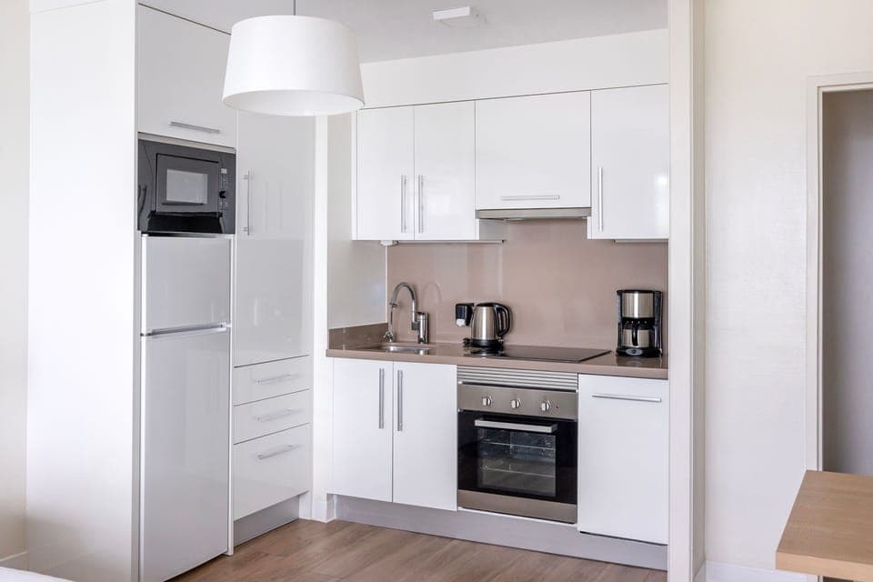 Modern kitchen amenities including a dishwasher, fridge, and hob ensure a seamless and comfortable stay.