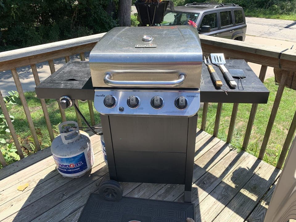 BBQ gas grill with utensils.