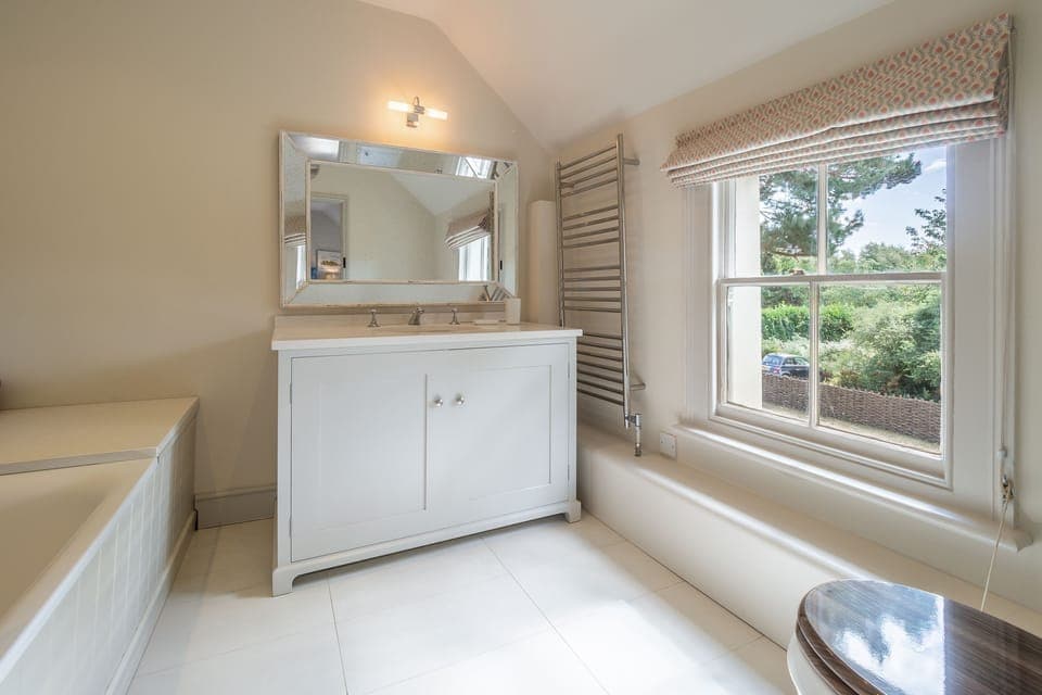 First floor: En-suite bathroom with bath with rainfall shower over, wash basin and WC